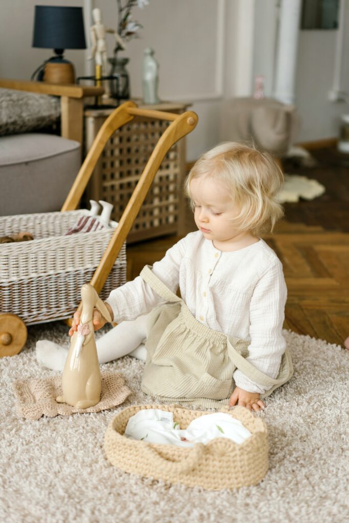 a young girl sitting on the carpet flattening her toy