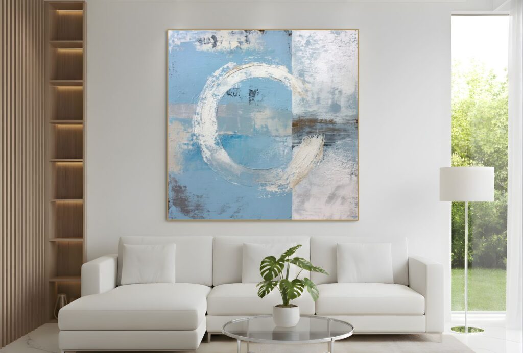 Abstract blue and white circular painting above sofa – A contemporary living room with a white sofa and a square abstract painting in soft blues and whites, featuring circular shapes, above the sofa.