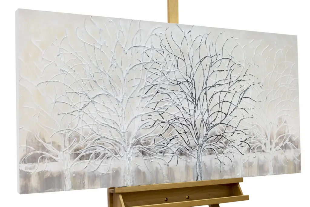 An abstract painting on an easel featuring scratchy grey lines that resemble winter trees or sketches on a white background.
